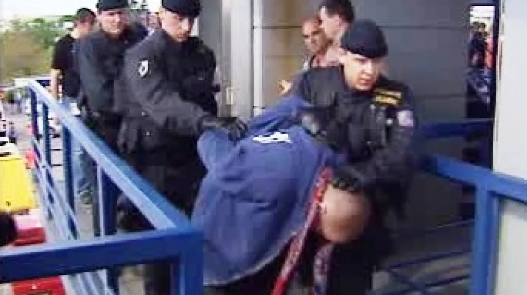 Policie odvádí fotbalového výtržníka.