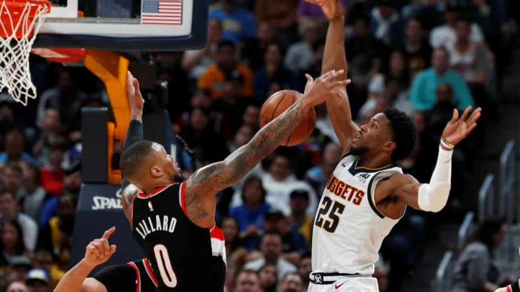 Damian Lillard z Portlandu blokuje Malika Beasleyho z Denveru