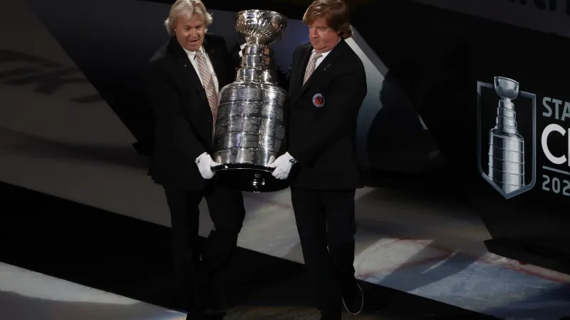 Phil Pritchard (vlevo) nese Stanley Cup společně s Mikem Boltem po finále play-off NHL 2022 mezi Coloradem a Tampou Bay