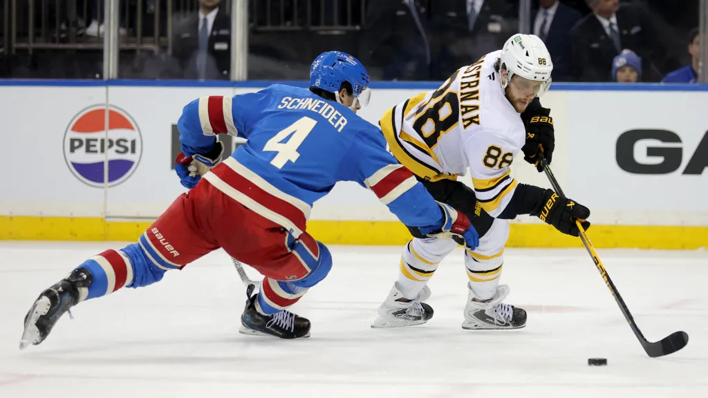 David Pastrňák a Braden Schneider v utkání Bruins s Rangers