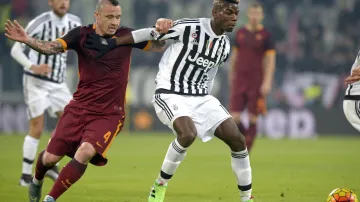 Paul Pogba (vpravo) z Juventusu si kryje míč před Radjou Nainggolanem z AS Řím