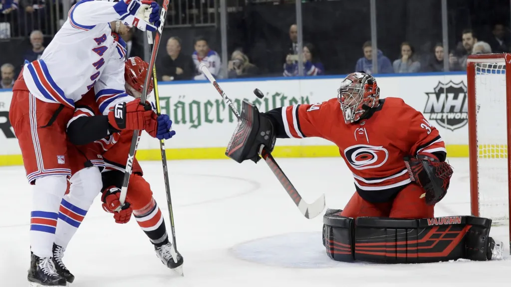 Brankář Caroliny Petr Mrázek (vpravo) v utkání NHL proti New York Rangers
