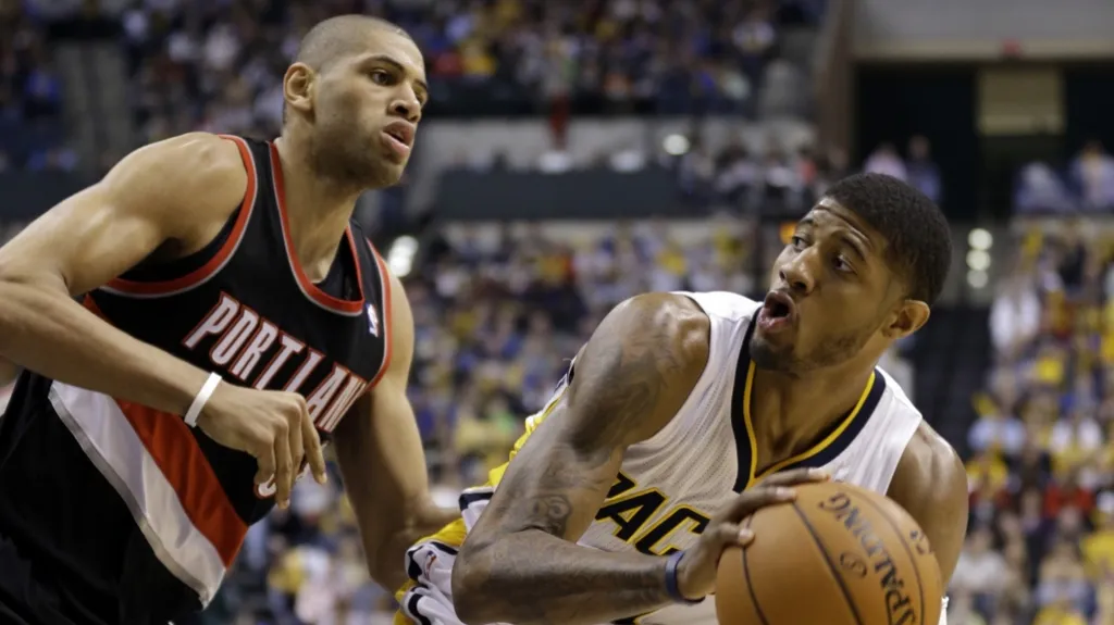 Paul George z Indiany bráněný Nicolasem Batumem