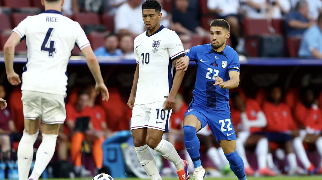 Anglický záložník Jude Bellingham si kryje míč před Slovincem Adamem Gnezdou Čerinem