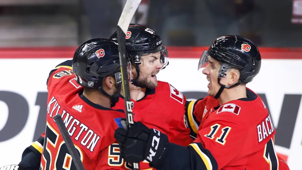 Michael Frolík (uprostřed) se raduje z gólu se spluhráči z Calgary