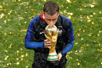 Francouz Antoine Griezmann líbá trofej pro mistry světa