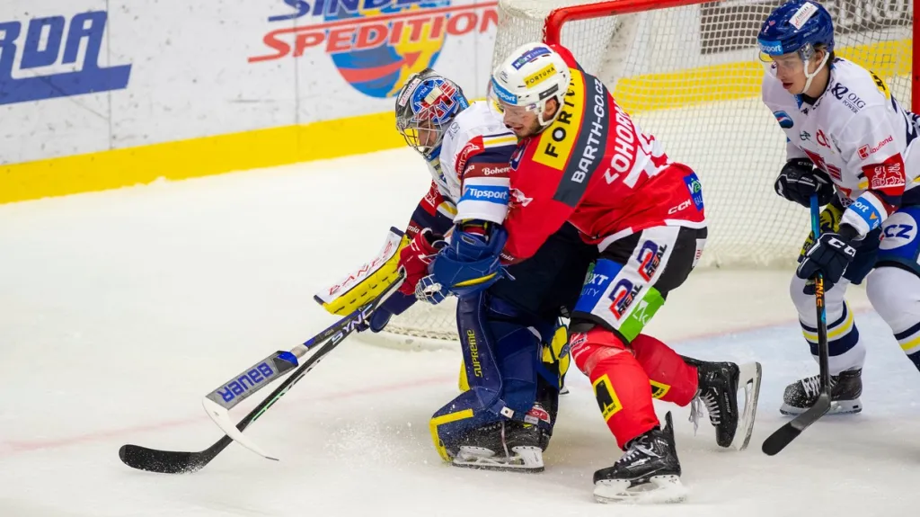 Brankář Motoru Jan Strmeň si chrání puk před pardubickým Tomášem Zohornou