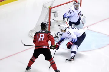 Kanaďan Pierre-Luc Dubois překonává amerického brankáře Coryho Schneidera