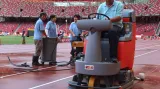 Čištění dráhy Mondo na olympijském stadionu v Pekingu