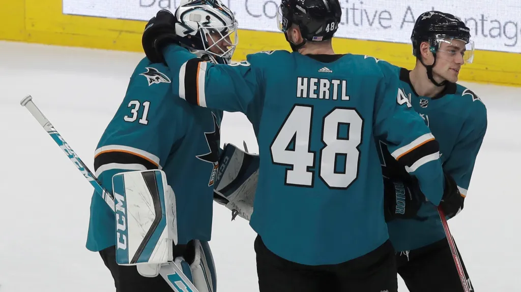 Tomáš Hertl oslavuje se spoluhráči ze San Jose vítězství v utkání NHL