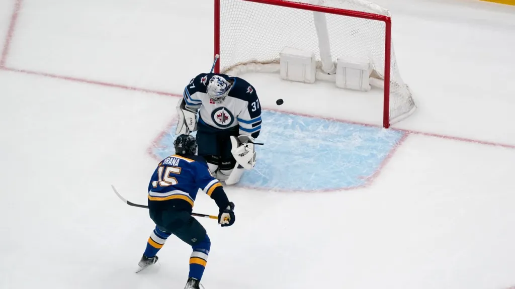 Jakub Vrána ze St. Louis překonává Connora Hellebuycka z Winnipegu