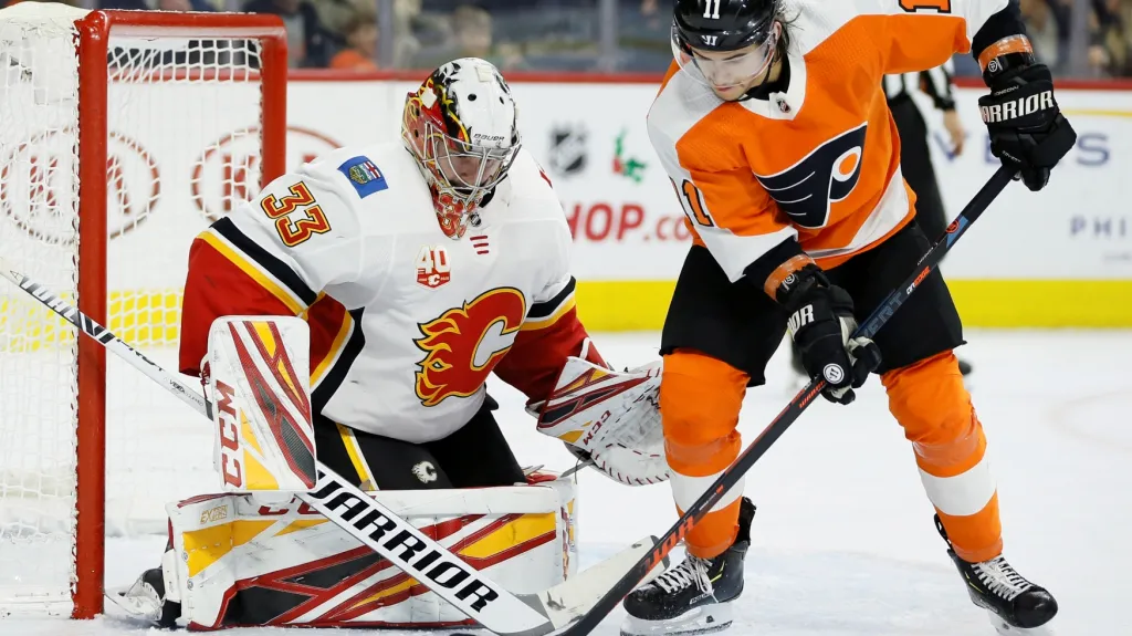 Brankář Calgary David Rittich proti Travisi Konecnymu z Philadelphie