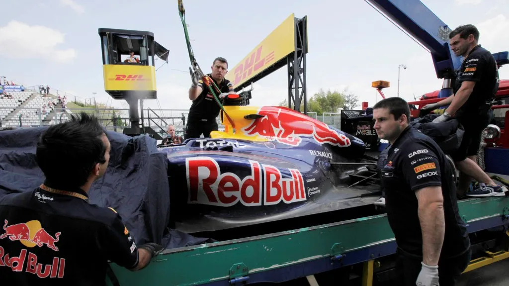 Členové týmu Red bull odklízejí Vettelův vůz