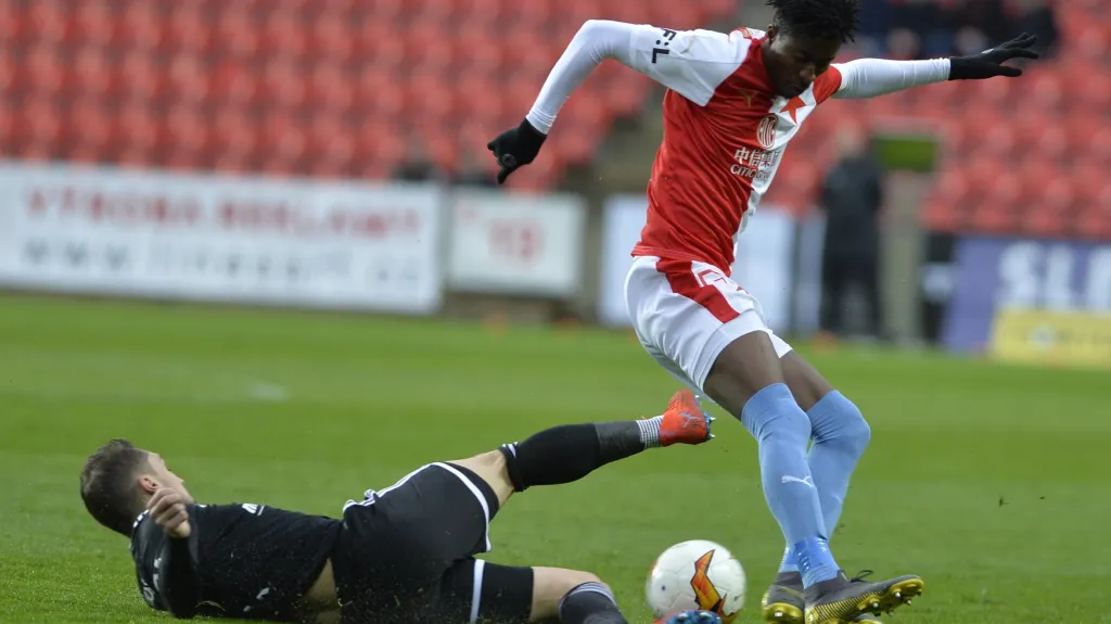 Adam Jánoš z Baníku se snaží skluzem zastavil Petera Olayinku ze Slavie