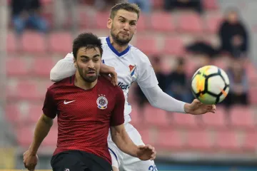 Sparťan David Hovorka si pokrývá míč před Tomášem Poznarem z Baníku Ostrava