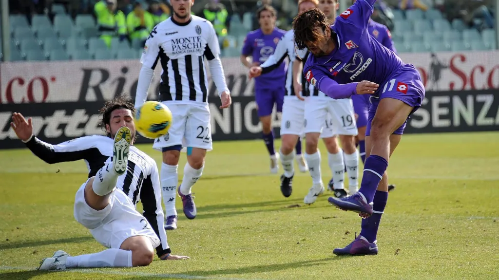 Emanuele Pesoli v dresu Sieny se snaží zabránit střele Brazilce Amauriho