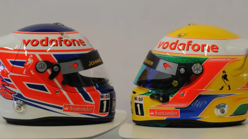 Přilby Lewise Hamiltona a Jensona Buttona