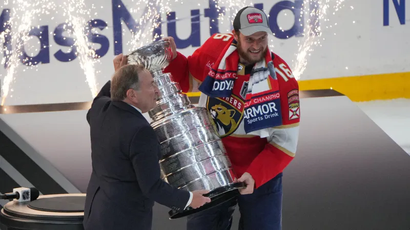 Komisionář NHL Gary Bettman předává Stanley Cup kapitánovi Floridy Alexandru Barkovovi
