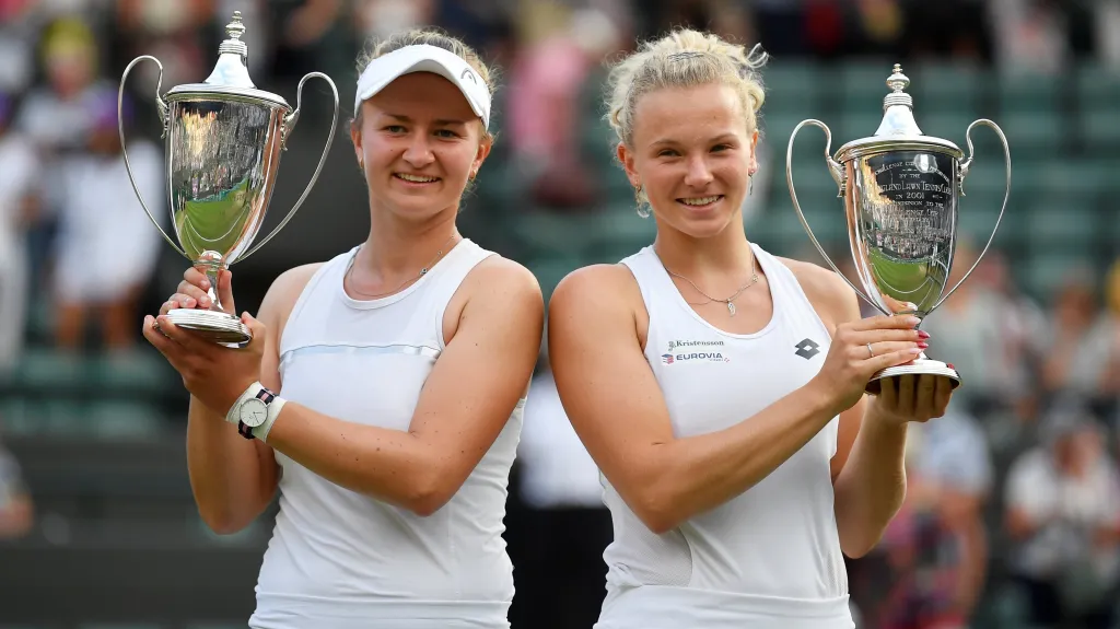 Barbora Krejčíková (vlevo) a Kateřina Siniaková s trofejemi pro vítězky čtyřhry na Wimbledonu