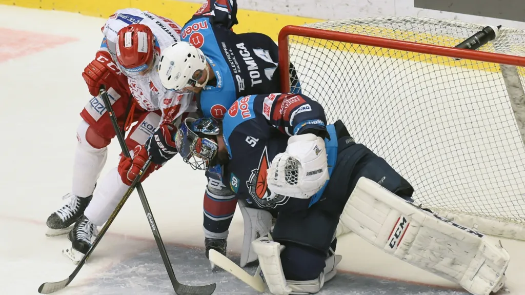 Ján Laco zasahuje proti střele Tylera Redenbacha z Třince