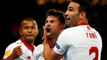 Sevillský Coke se raduje se spoluhráči z gólu