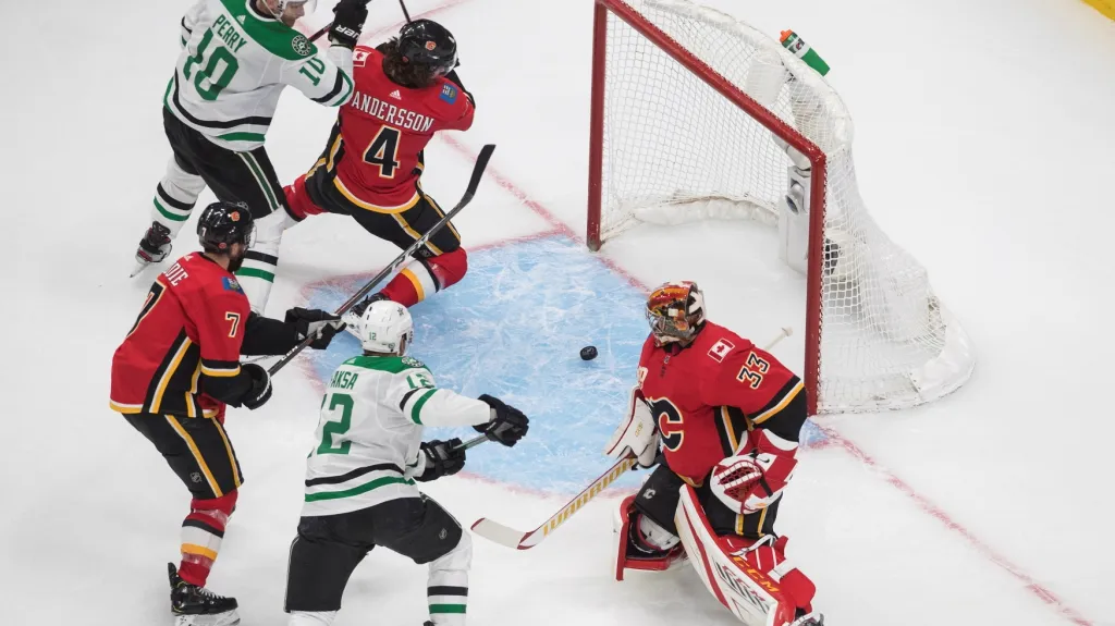 Brankář Calgary David Rittich sleduje puk v brankovišti v duelu s Dallasem