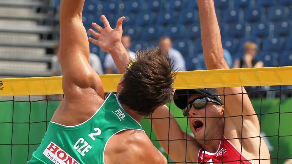 Beachvolejbalista Jan Hadrava smečuje na síti při MS