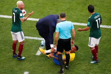 Brazilec Neymar leží na zemi po kontaktu s Mexičany