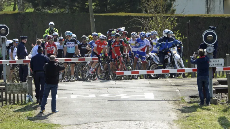 Část pelotonu zastavil projíždějící vlak