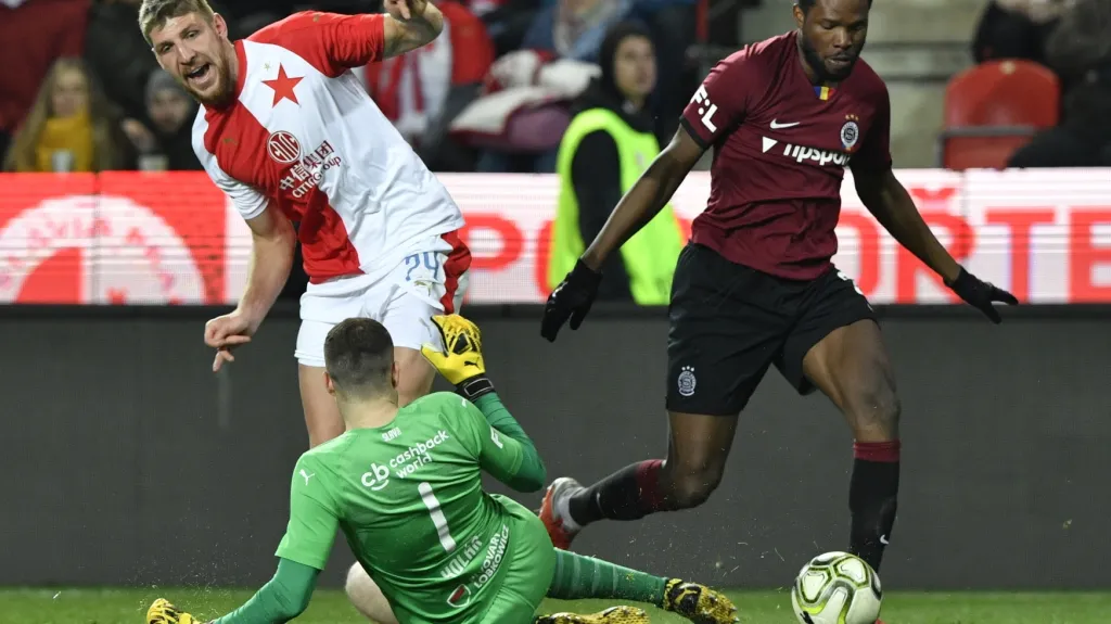 Ladislav Takács a brankář Slavie Ondřej Kolář v souboji s Benjaminem Tettehem