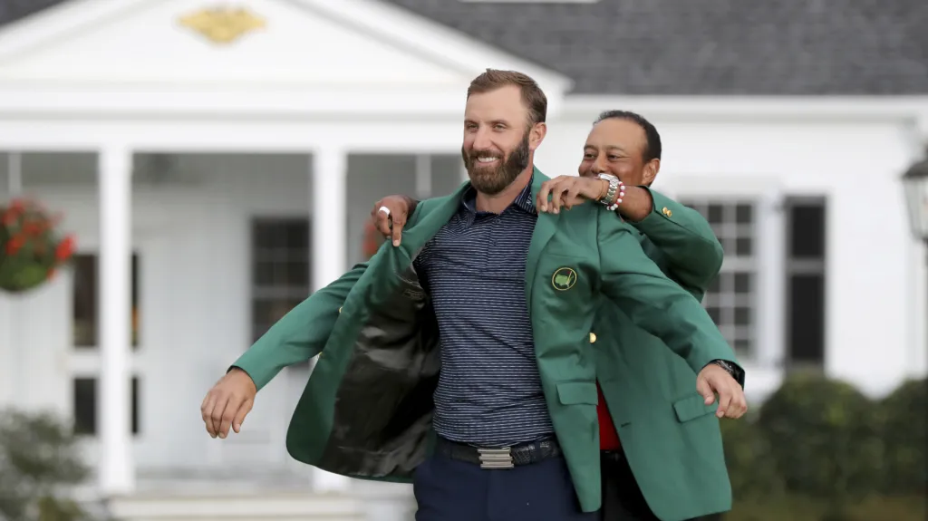 Dustinu Johnsonovi dle tradice zelené sako předal předchozí vítěz Tiger Woods