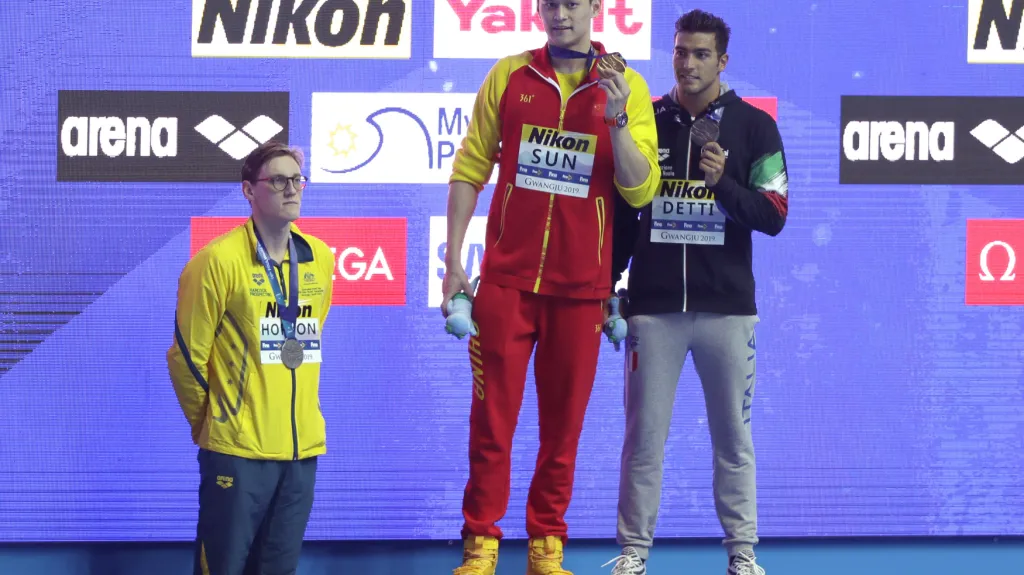 Australan Mack Horton přihlíží za stupni vítězů zlatému Číňanovi Sun Jangovi