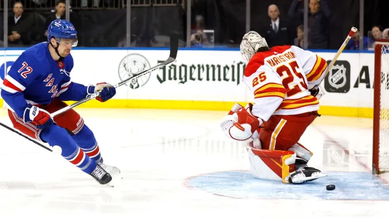 Filip Chytil z NY Rangers překonává Jacoba Markströma z Calgary
