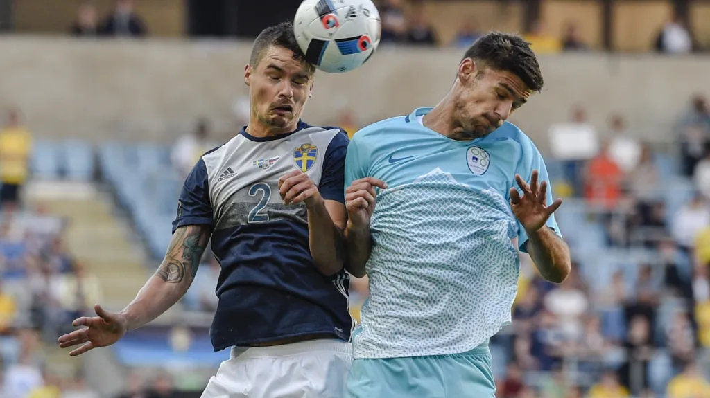 Švéd Mikael Lustig (vlevo) v hlavičkovém souboji s Rokem Kronaveterem ze Slovinska