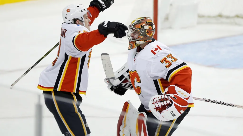 Brankář David Rittich se raduje s Matthewem Tkachukem