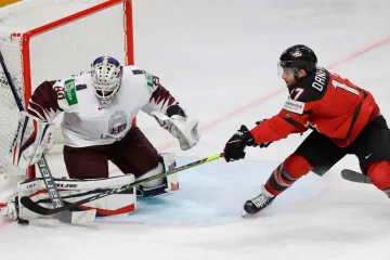 Lotyšský brankář Matiss Kivlenieks zasahuje před Justinem Danforthem