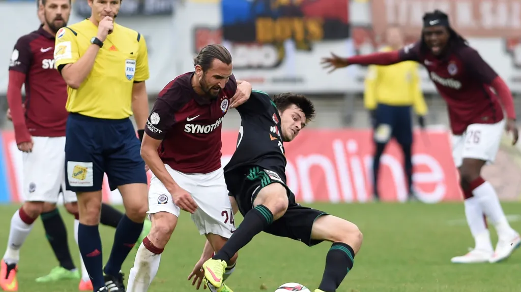 Sparťan Marek Matějovský (vlevo) přihlíží souboji mezi Petrem Jiráčkem a Martinem Kramešem z Příbrami