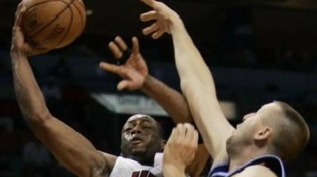 Basketbalista Dwyane Wade (vlevo) z Miami Heat dává koš před bránícím Gregem Ostertagem z Utah Jazz. 
