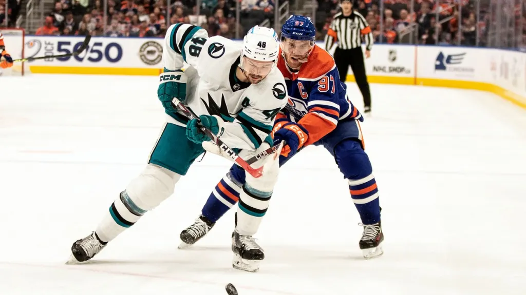 Tomáš Hertl (vlevo) ze San Jose v souboji s Connorem McDavidem z Edmontonu