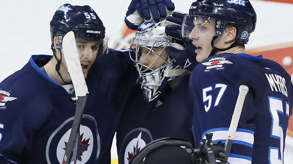 Ondřej Pavelec (uprostřed) slaví výhru se svými spoluhráči z Winnipegu