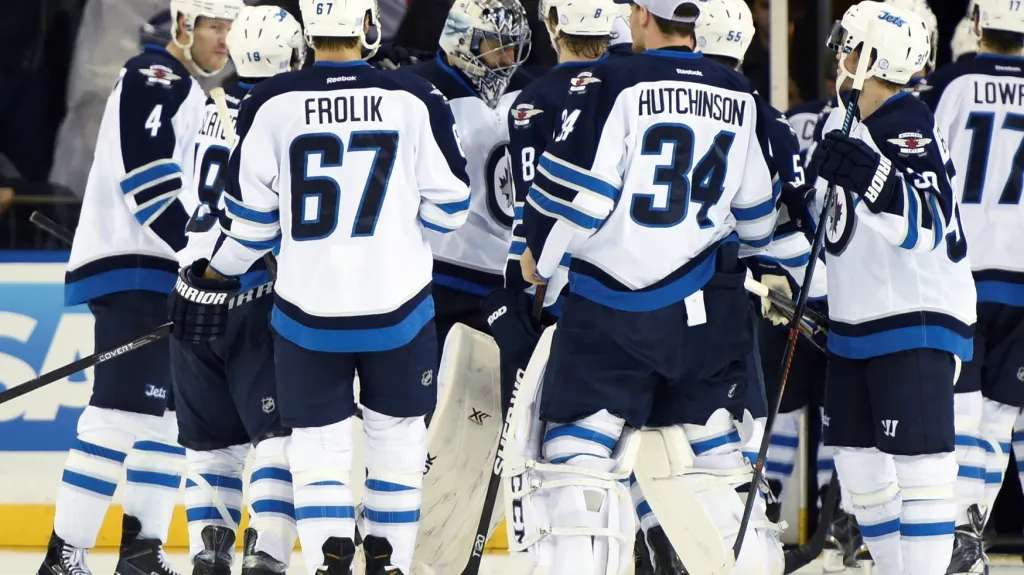 Brankář Ondřej Pavelec (uprostřed) slaví se svými spoluhráči z Winnipegu vítězství