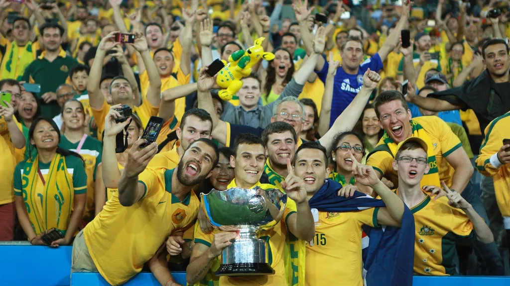 Fotbalisté Austrálie pózují s pohárem a fanoušky po výhře ve finále nad Jižní Koreou