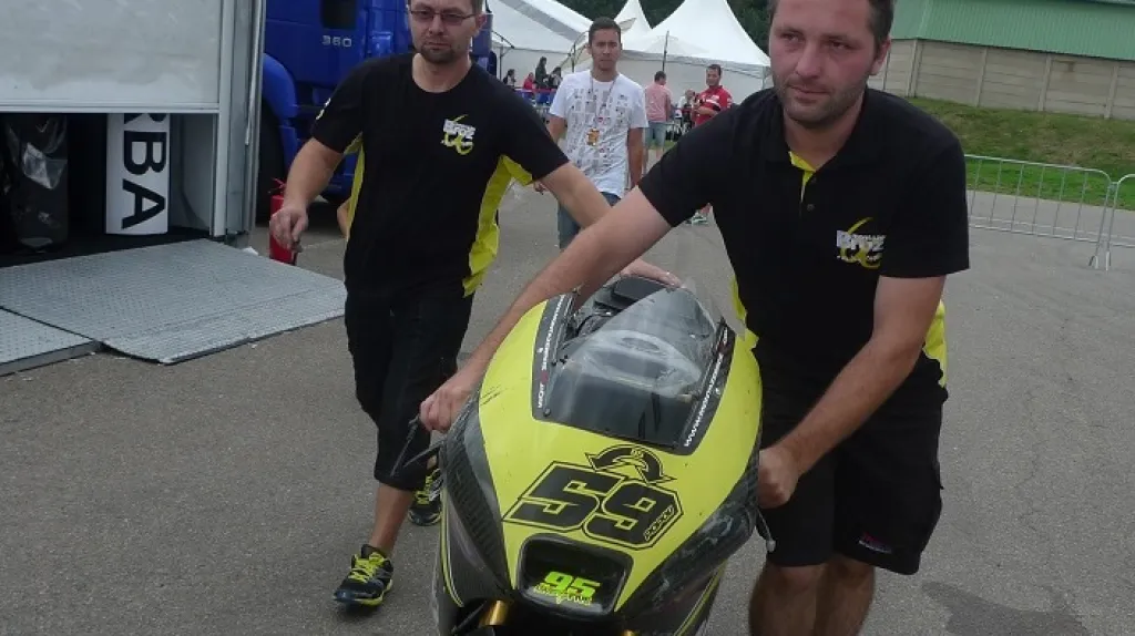 Mechanici tlačí zpět do stanu omlácenou motorku Miroslava Popova