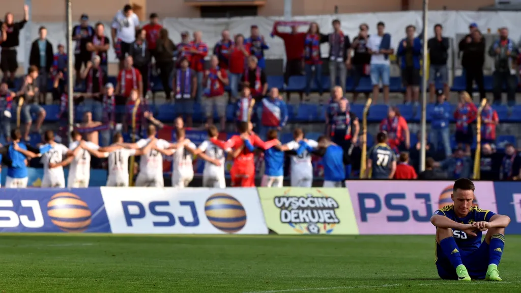 Zklamaný jihlavský Davis Ikaunieks a v pozadí se slavící fotbalisté Plzně