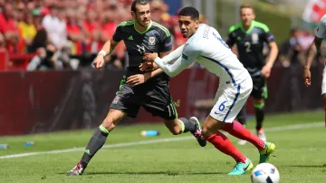 Velšan Gareth Bale se snaží uniknout Chrisu Smallingovi z Anglie