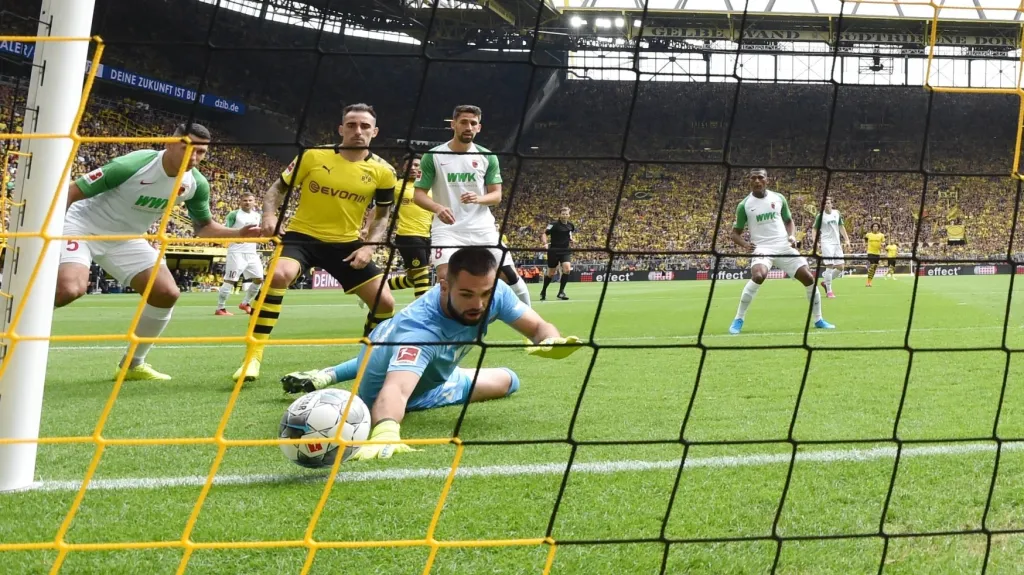 Tomáš Koubek z Augsburgu se snaží zasáhnout proti míči na stadionu Dortmundu