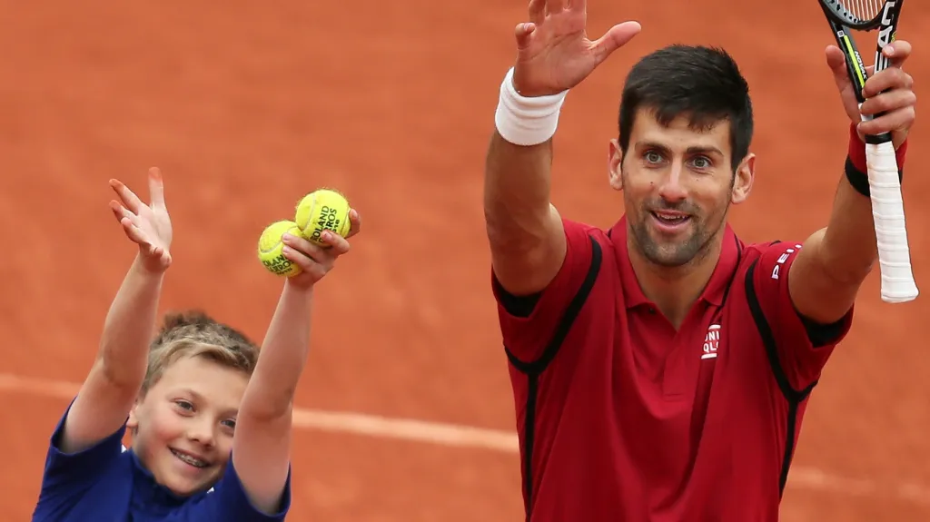 Novak Djokovič se na French Open raduje s jedním z podavačů míčků
