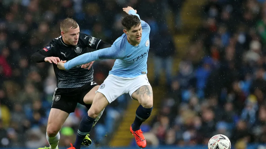 Útočník Burnley Matěj Vydra v souboji s Johnem Stonesem