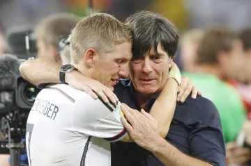 Dojatý trenér Německa Joachim Löw (vpravo) v objetí s Bastienem Schweinsteigerem