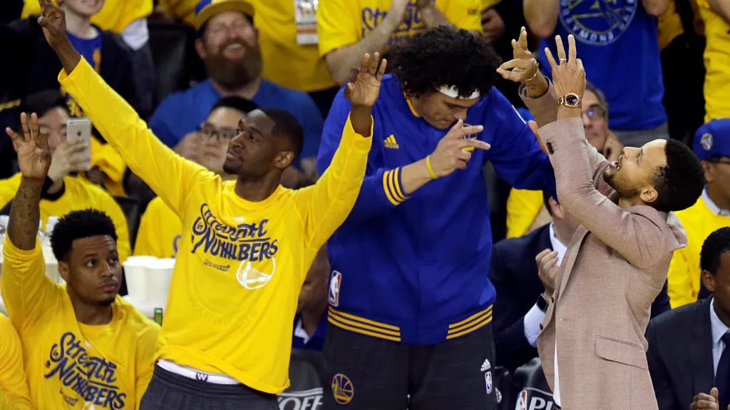 Zraněný Stephen Curry (vpravo) slaví se svými spoluhráči z Golden State